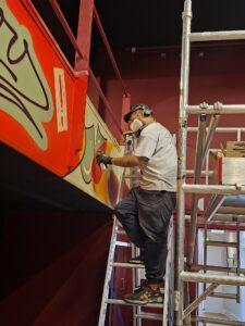 Guilherme Luã Pereira completing mural